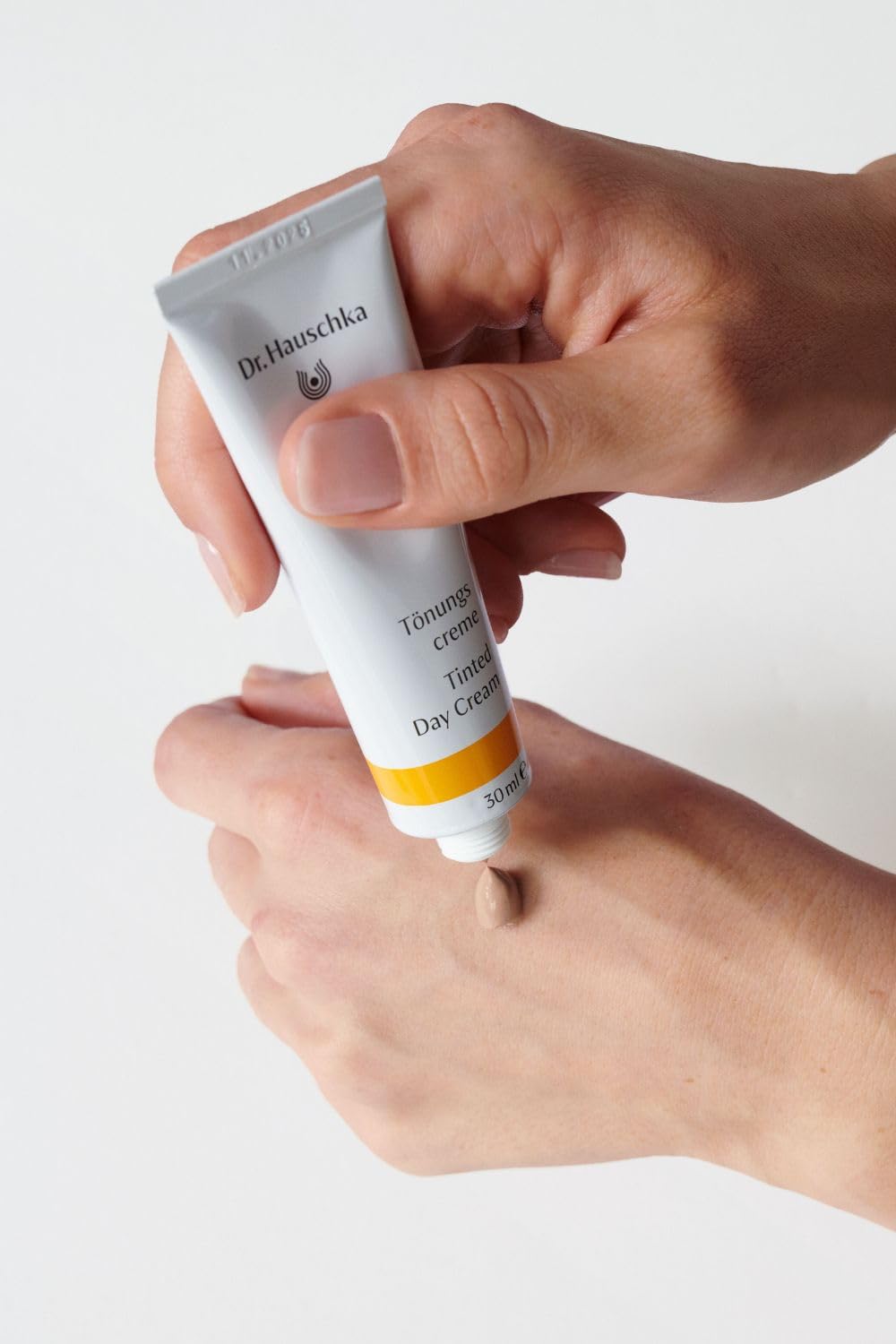 Skin swatch shows natural sun-kissed tone from the tinted day cream.