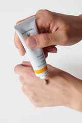 Skin swatch shows natural sun-kissed tone from the tinted day cream.