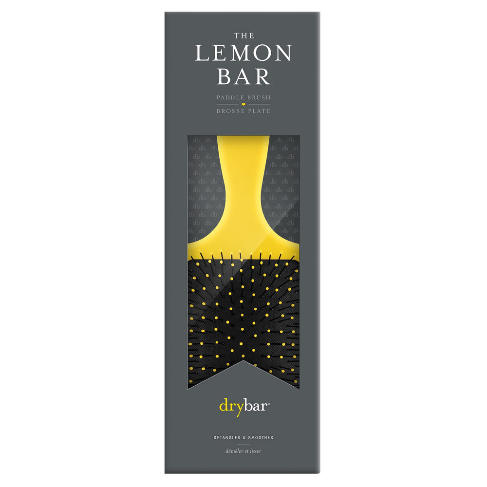 Drybar Lemon Bar Paddle Brush close-up shows flexible bristles for gentle detangling.