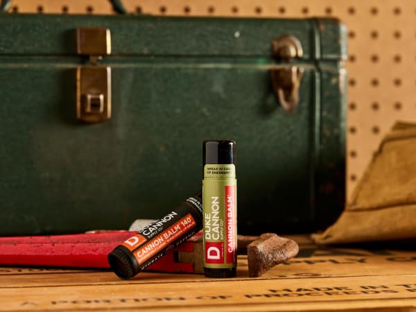 Duke Cannon lip balm on a work site, pocket-ready for quick reapplications