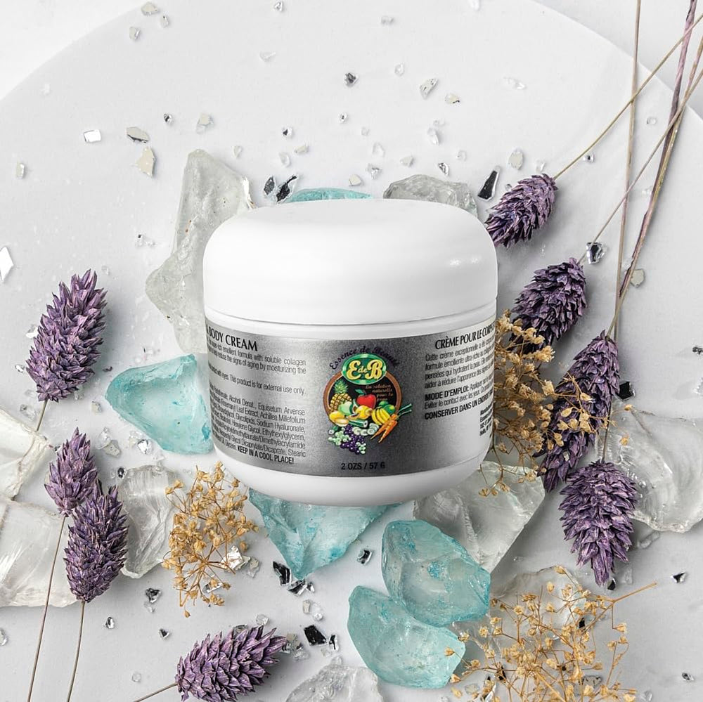 Close-up of E de B Essence cream being applied to skin for nourishment.