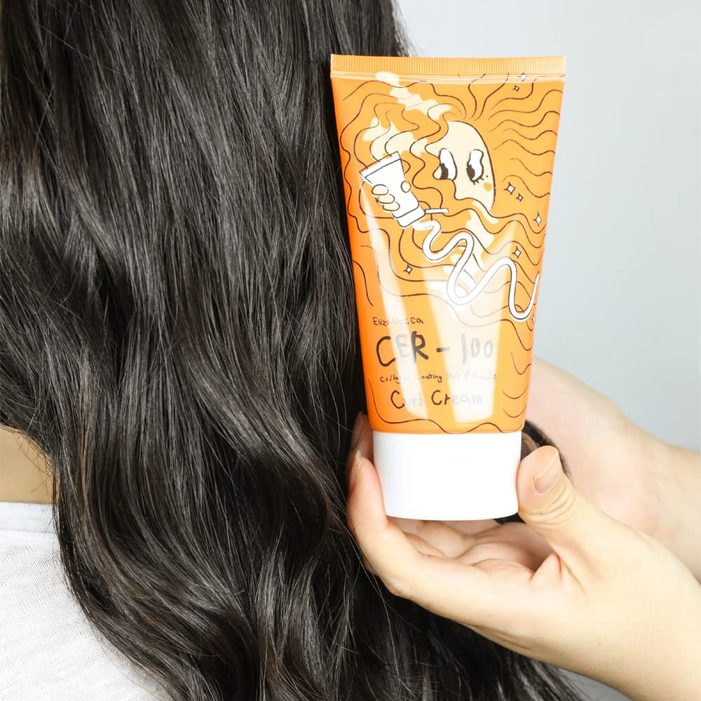 Hands applying Elizavecca CER-100 Curl Cream to damp hair.