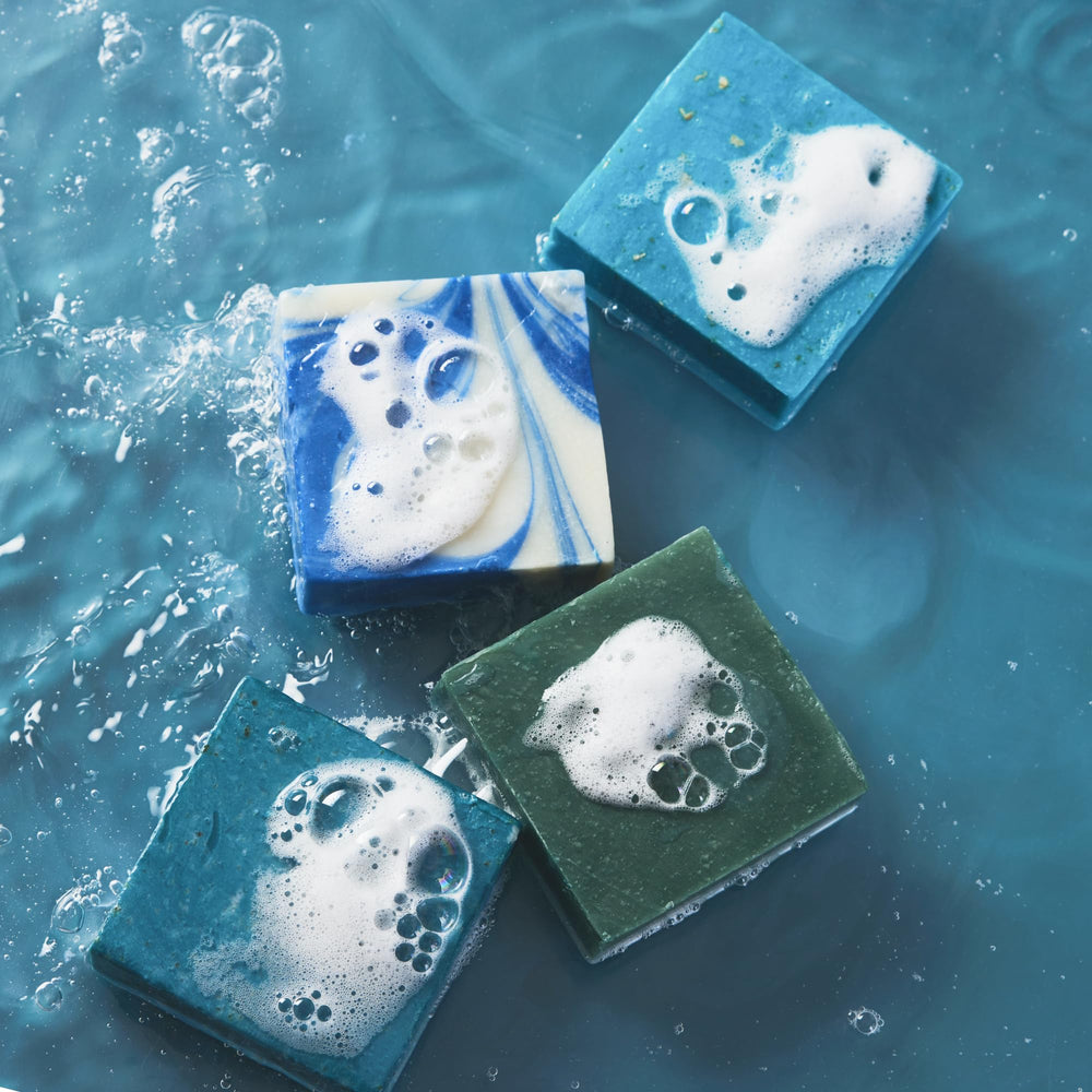 Every Man Jack Cold Plunge soap lather shown with loofah for rich foam.