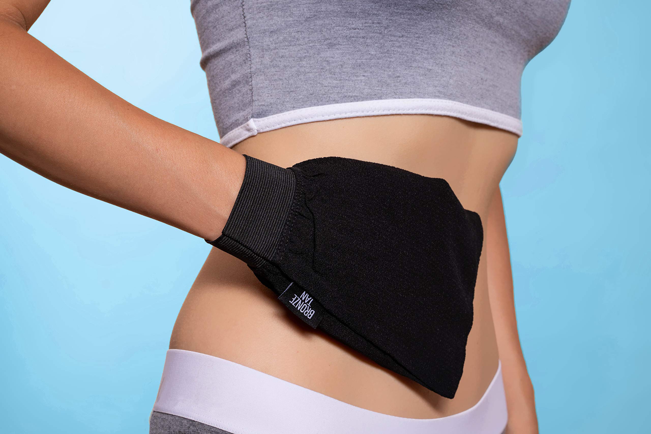 Existing Beauty Bronze Tan Remover Glove hand-application demonstrates pre-tan prepping for even results.