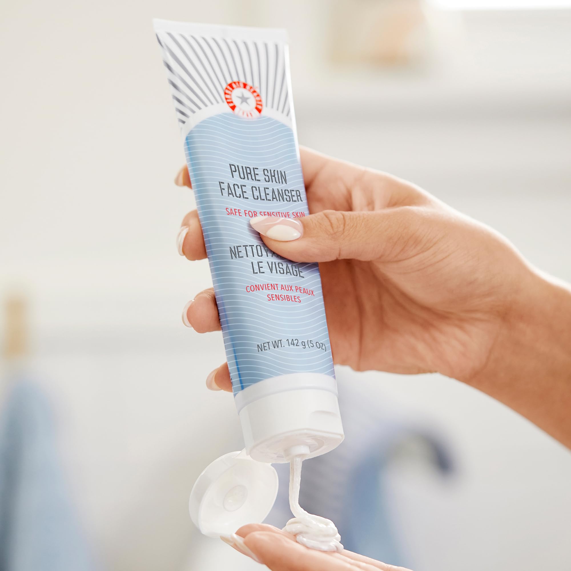 Pouring First Aid Beauty Pure Skin Face Cleanser to cleanse gently