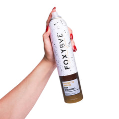 Aplicación del champú seco FoxyBae Brunette Breeze para controlar grasa y aportar volumen.