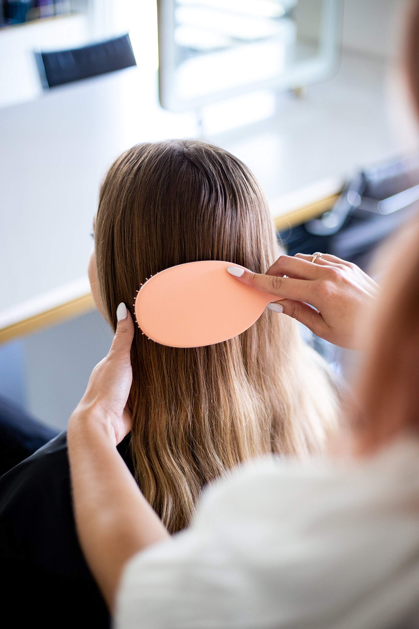 Framar Detangling Brush with elegant champagne design on vanity.