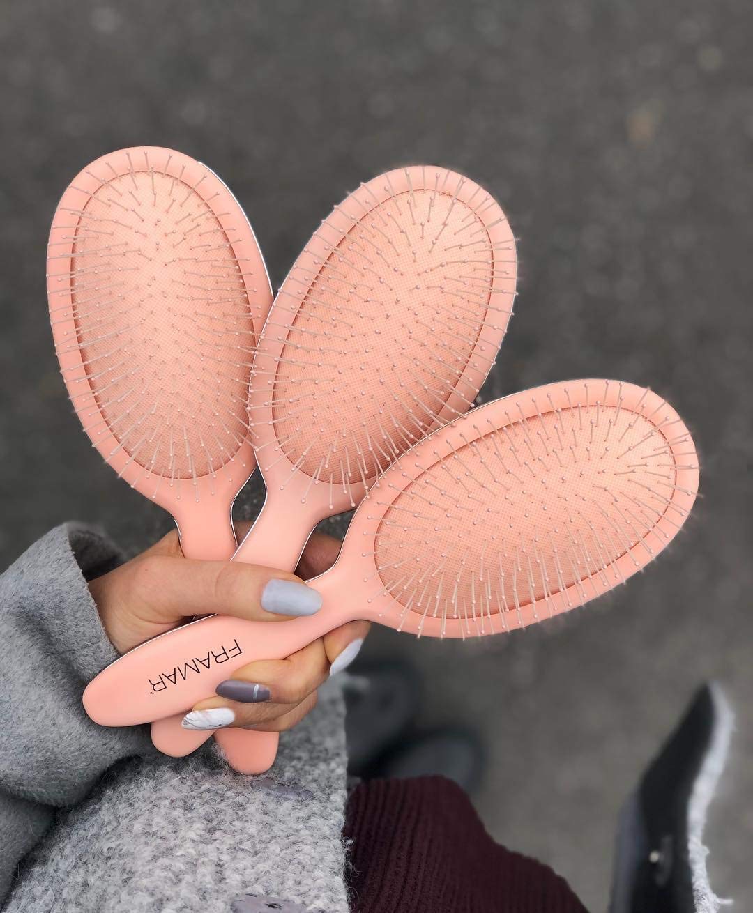 Framar Detangling Brush demonstrating scalp-friendly bristles for massage.