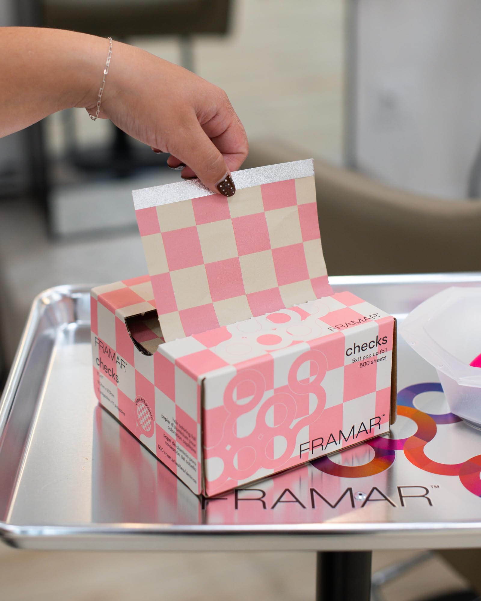 FRAMAR pink-checkered foil in use at chair enhances client experience.