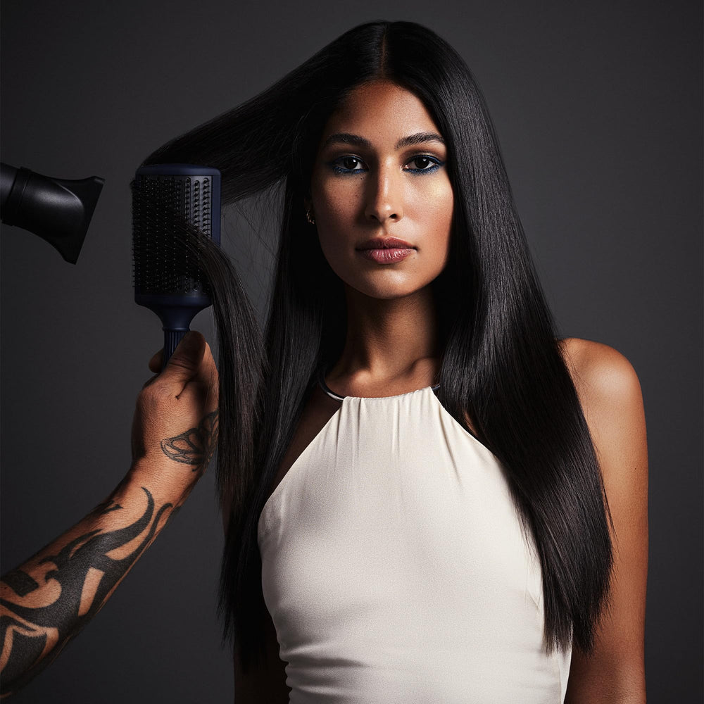 Fromm Intuition curved-base paddle brush lifting roots for added volume during styling.