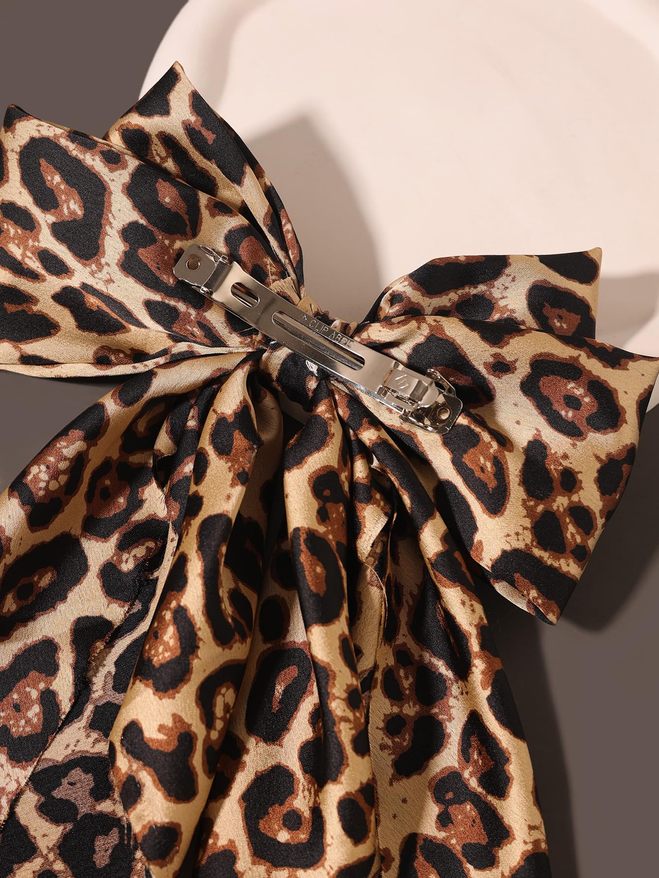 Furling Pompoms leopard bow on ponytail illustrates bold style for daily or party looks.