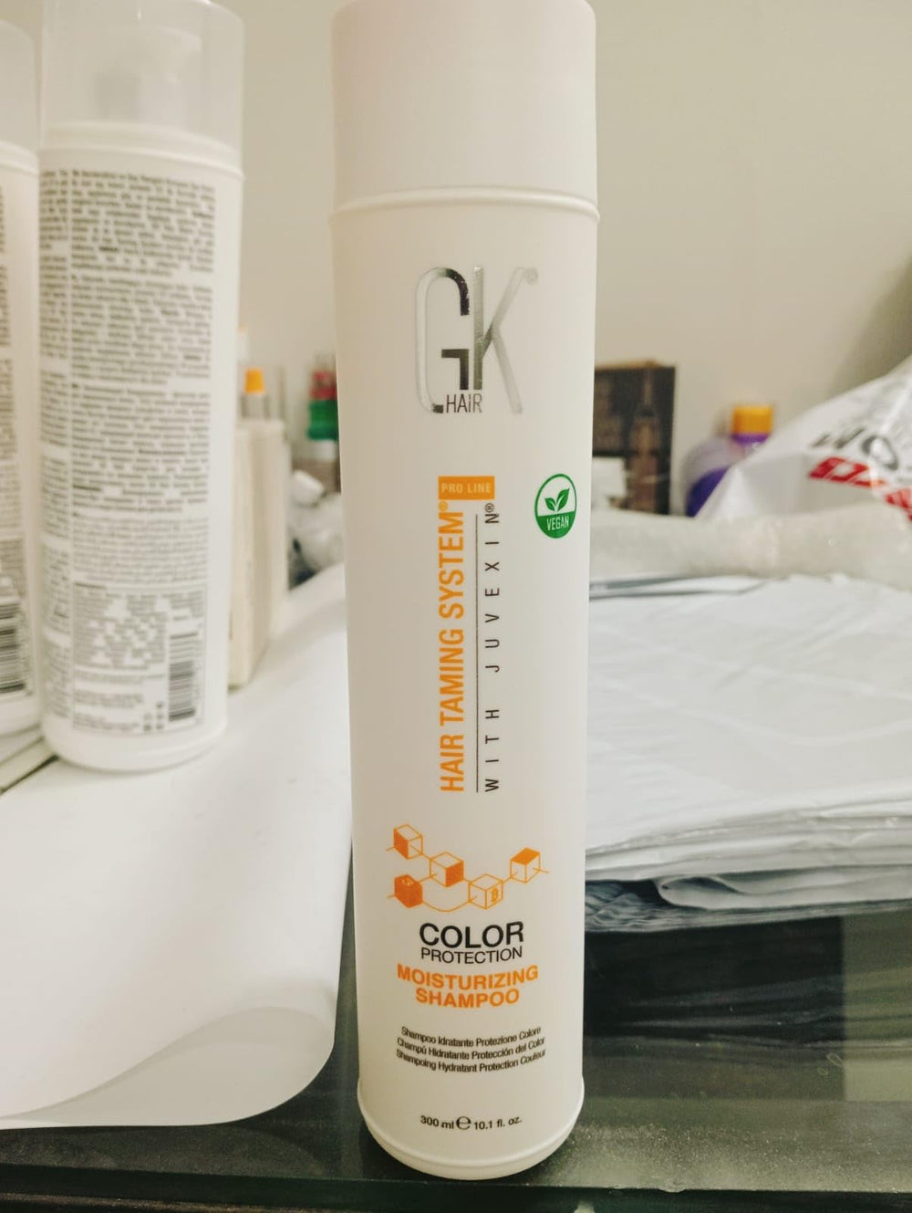 Rinse scene with GK Hair Moisturizing Shampoo cleansing strands.