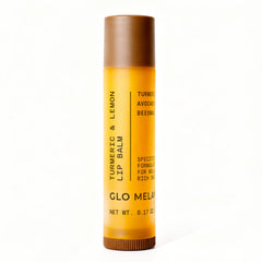 Bálsamo labial Glo Melanin con limón y cúrcuma en envase, brillo suave natural.