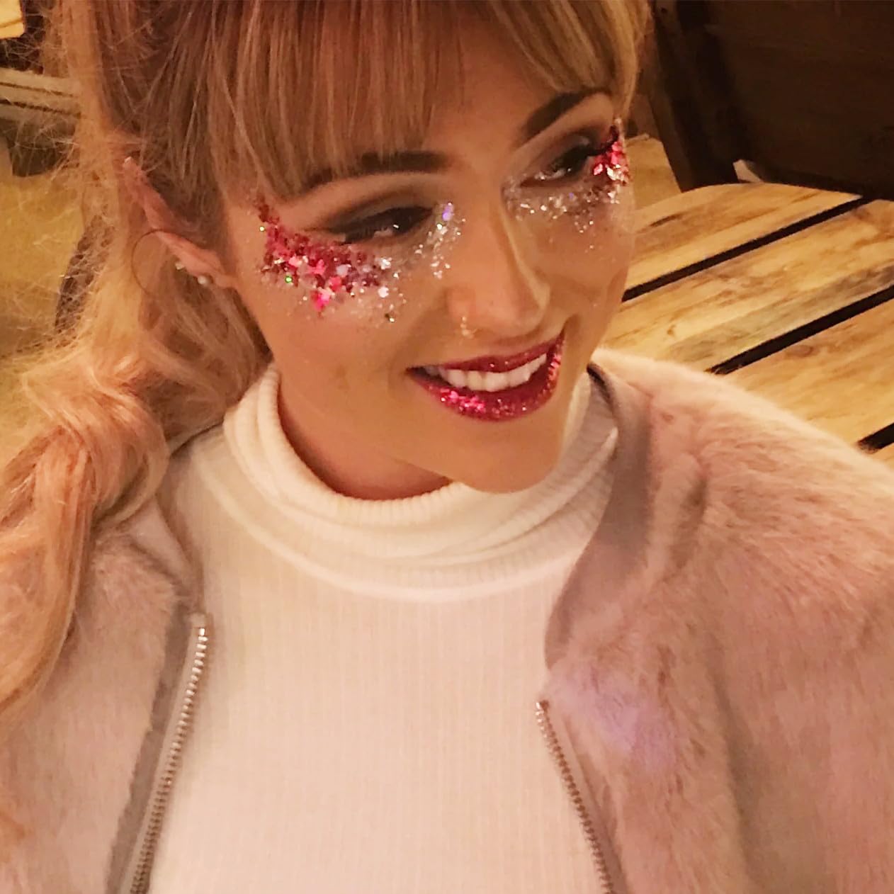 Go Ho red face glitter in hair creates cosmic festival sparkle.