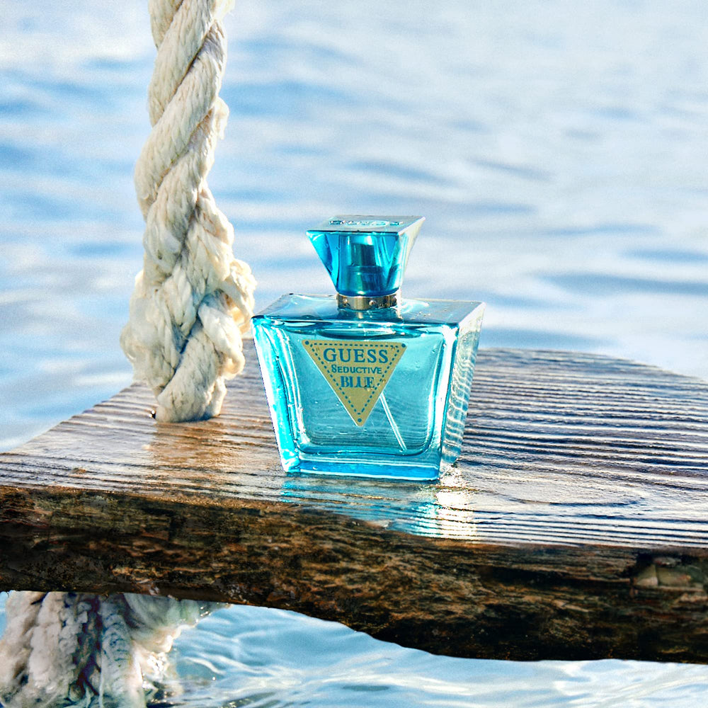 GUESS Seductive Blue lifestyle on sunlit beach, evokes seaside warmth and memories