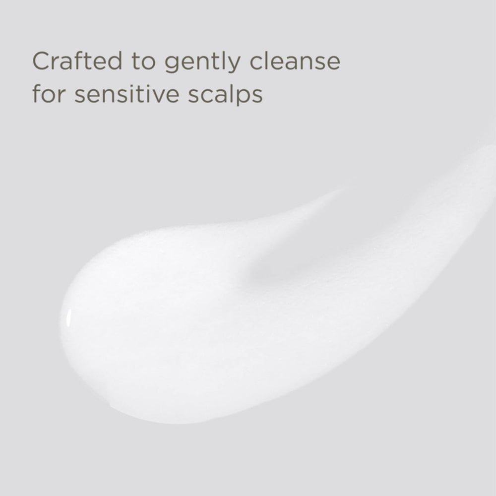 Hairitage champú Esencial, textura en la mano, aplicación suave para cabello.
