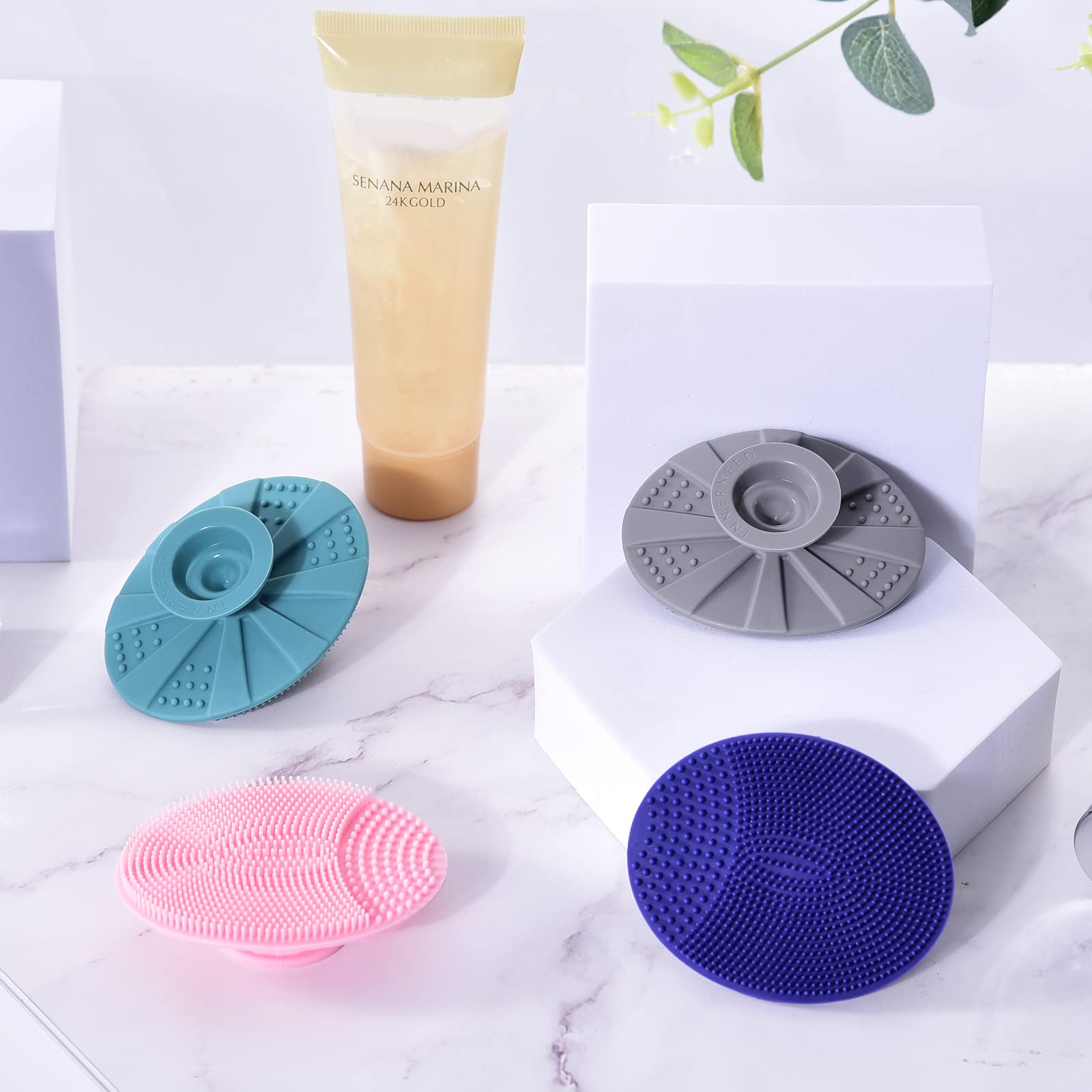 INNERNEED silicone face scrubber suction cup drying on glass or tile.
