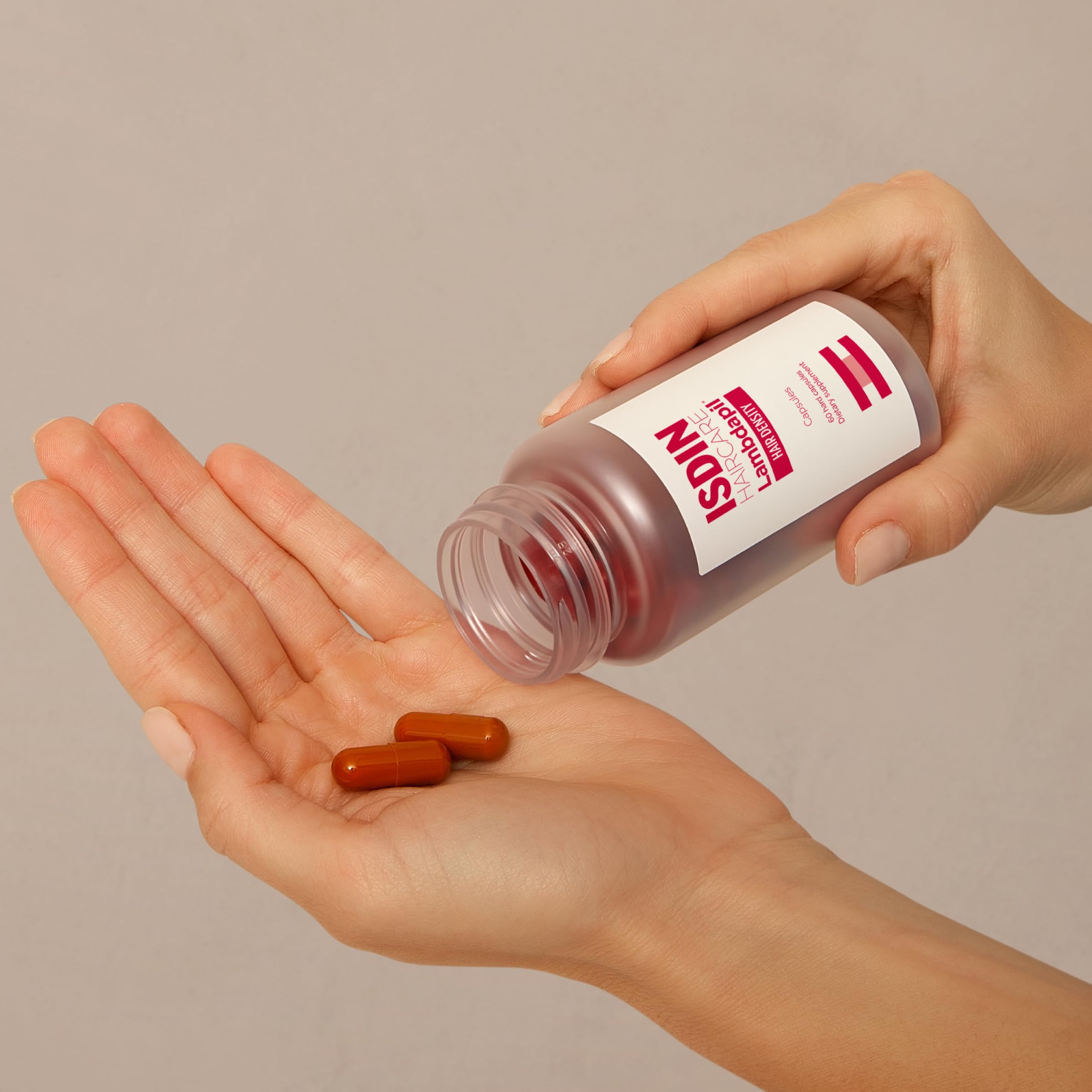 Close-up of ISDIN Lambdapil capsules emphasizing vitamin-rich formula for follicle nourishment.