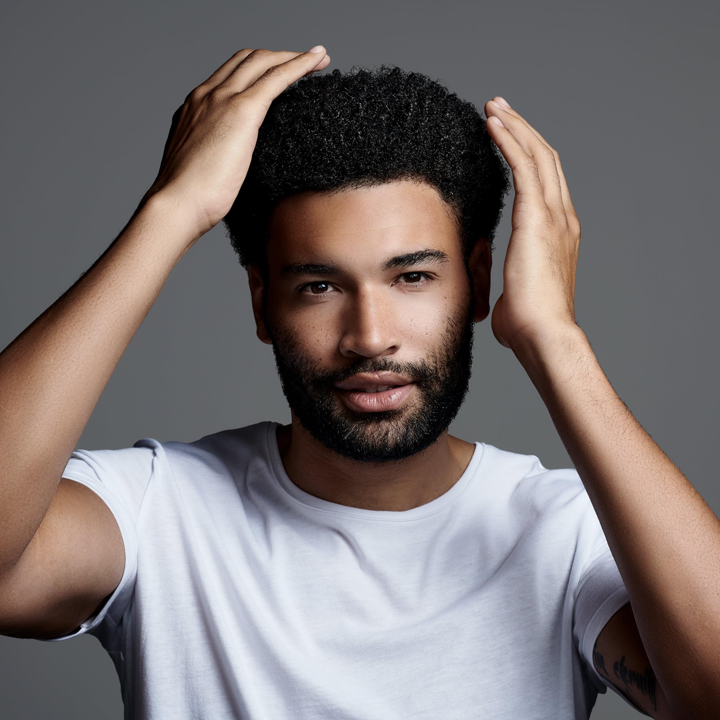 Jack Black Clay Pomade applied to textured hair for natural sculpting
