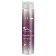 Joico Defy Damage Shampoo bottle being poured for color-safe cleansing
