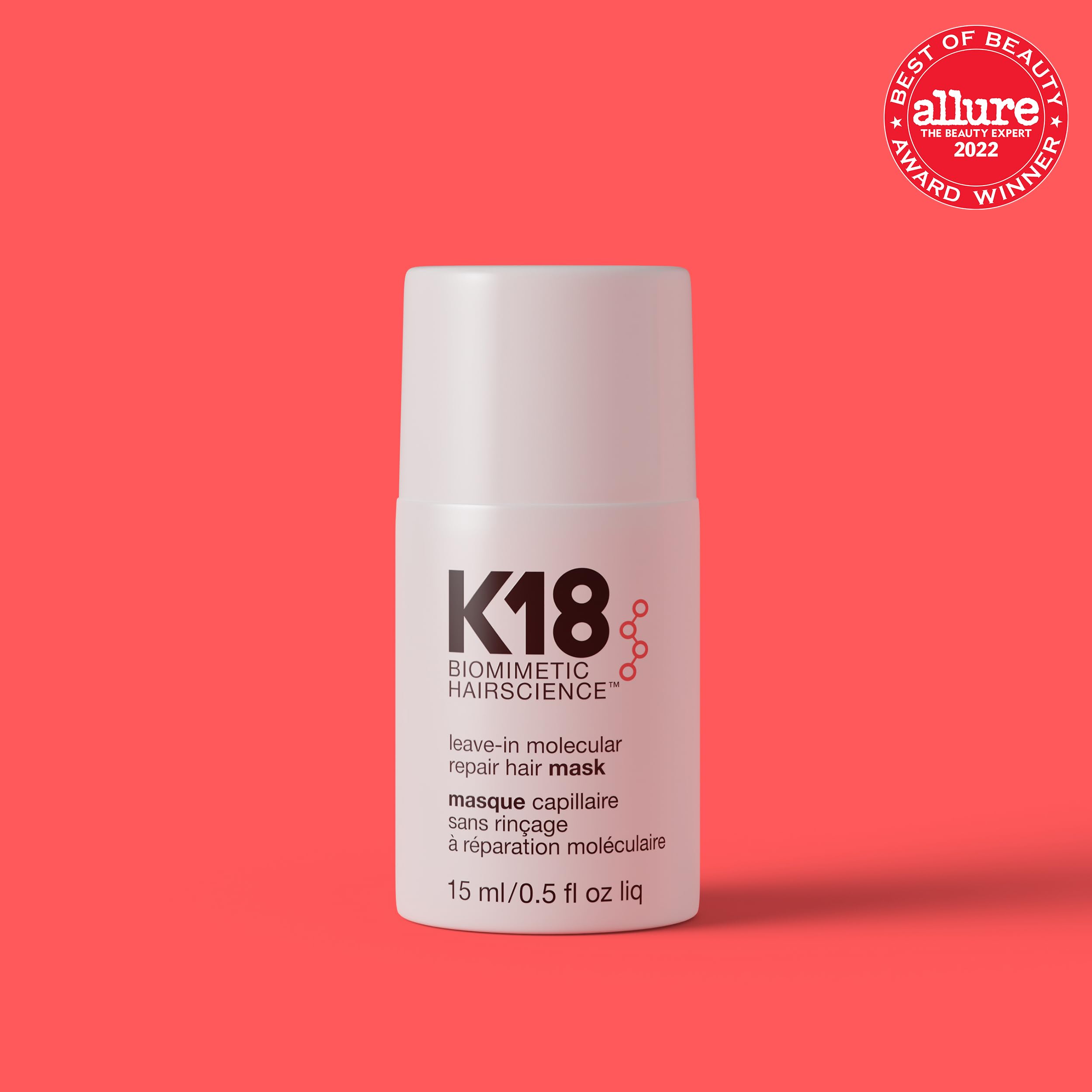 K18 leave-in bottle being applied for even distribution on damp hair.