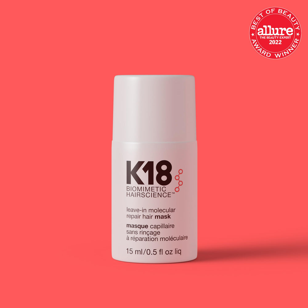 K18 leave-in bottle being applied for even distribution on damp hair.