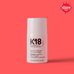 K18 leave-in bottle being applied for even distribution on damp hair.