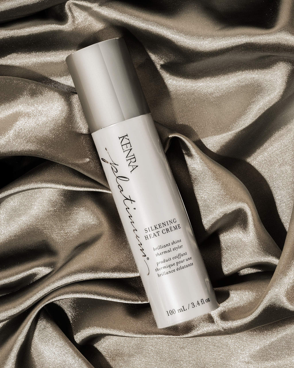Hands applying Kenra Platinum Silkening Heat Crème for smoothing prep
