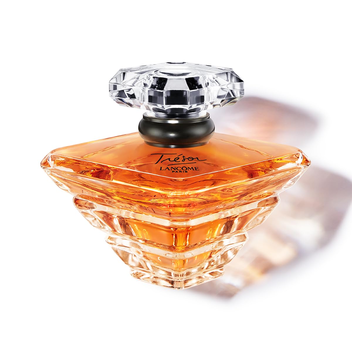 Lancôme Trésor bottle with crystal pyramid cap, elegant centerpiece for romance.
