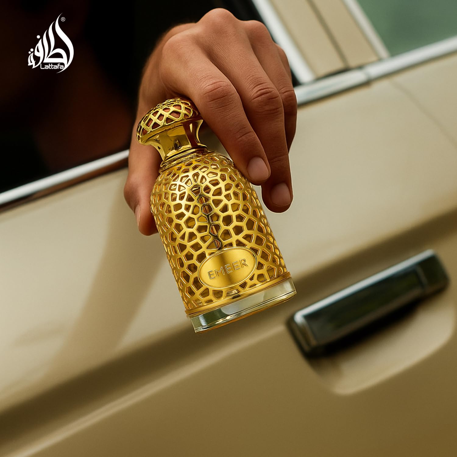 Lattafa Emeer bottle on wooden surface emphasizes warm base notes.
