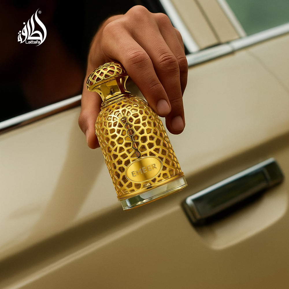 Lattafa Emeer bottle on wooden surface emphasizes warm base notes.