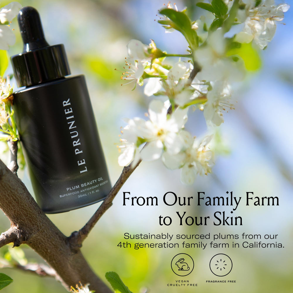 Face application of Plum Beauty Oil with a small droplet absorbed on the cheek.