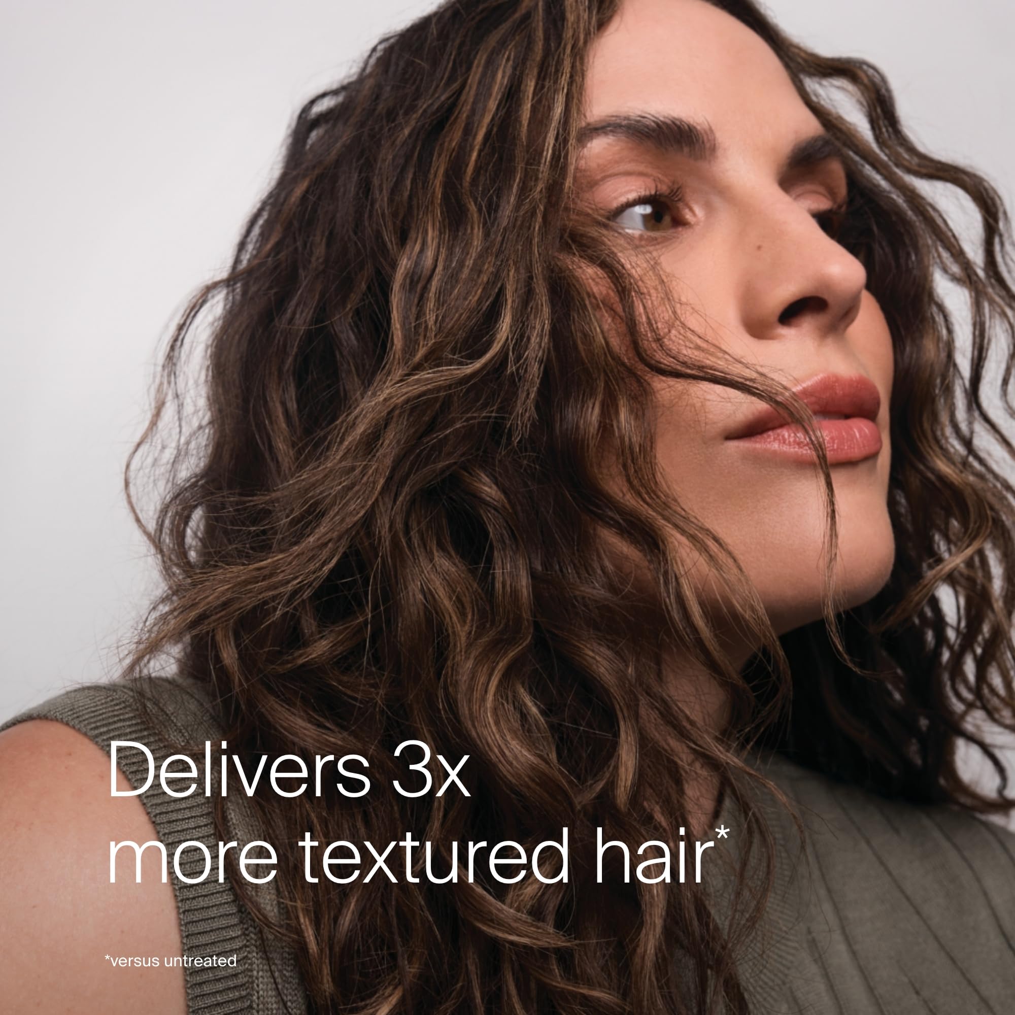 Hair forming beachy waves using Living Proof Full Texturizing Foam.