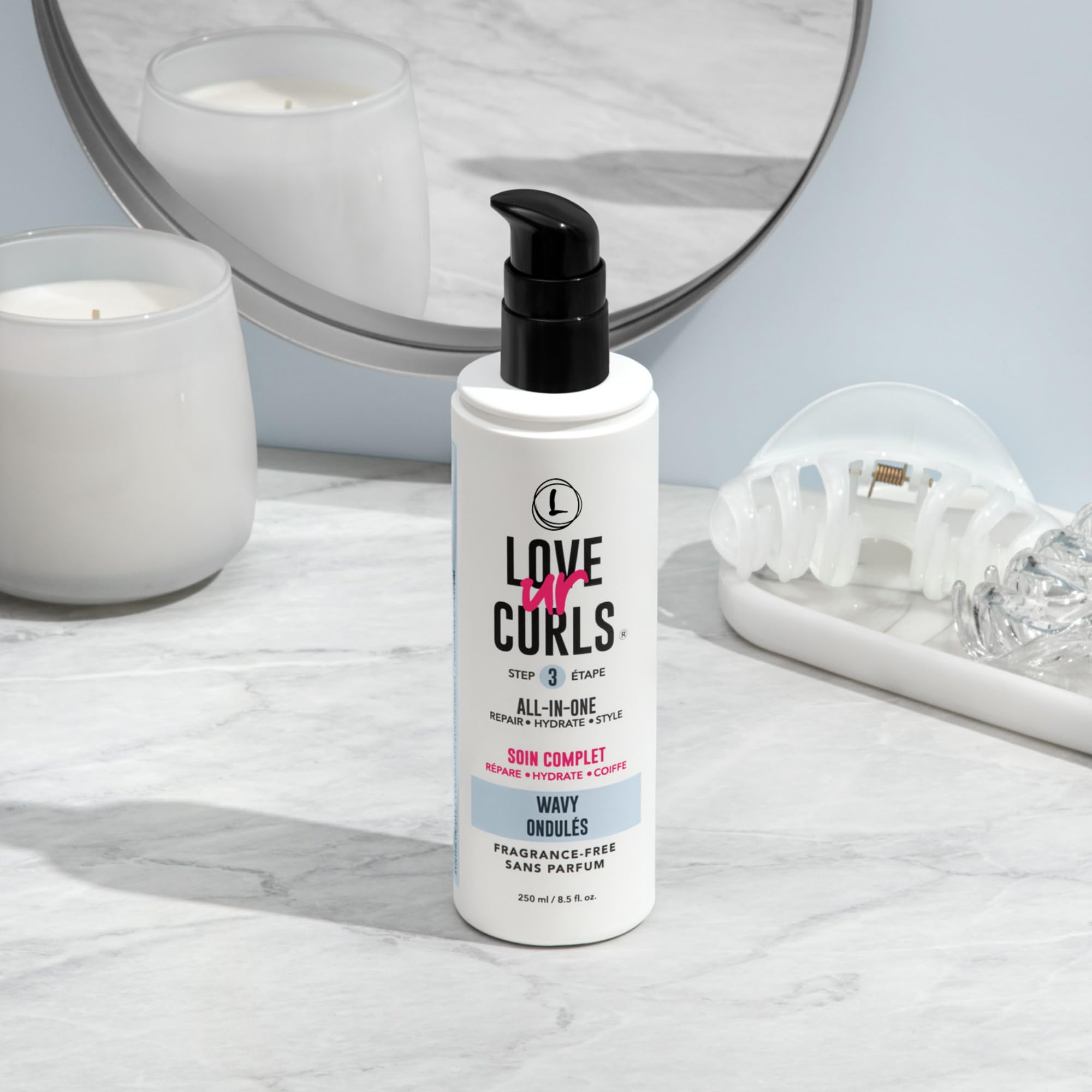 Hands applying Love Ur Curls cream to damp waves for hydration
