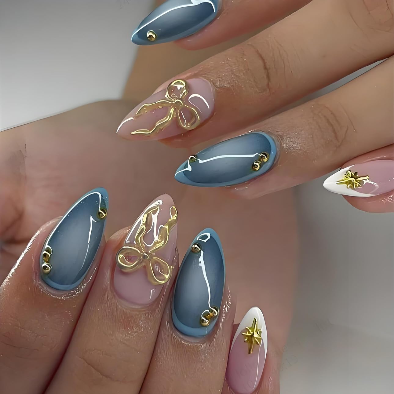 LPOODDNU 3D gold bow star nails with almond blue tips for salon-style at-home manicures.