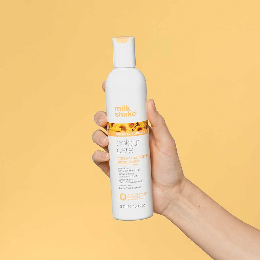 milk_shake Color Maintainer Conditioner hands applying on damp hair for even coverage