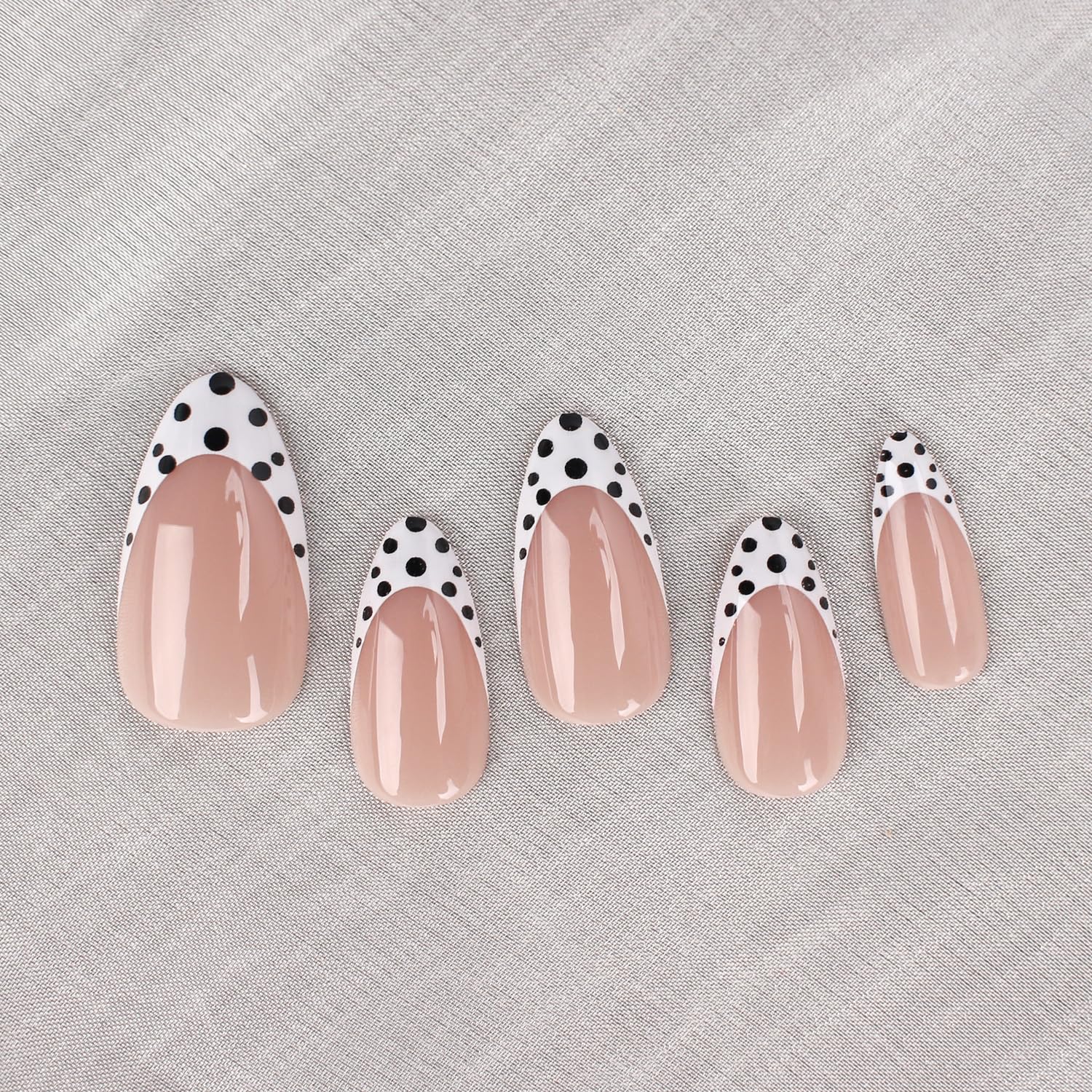 Uñas postizas Mivota almendra media, rosado claro, brillo y lunares negros y blancos.