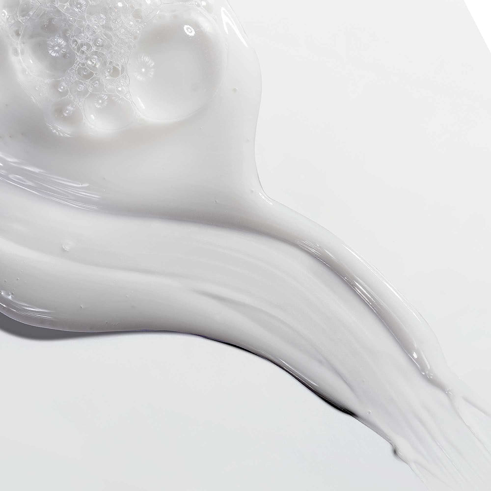 Liquid shampoo formula highlighting smooth application and humidity resistance.