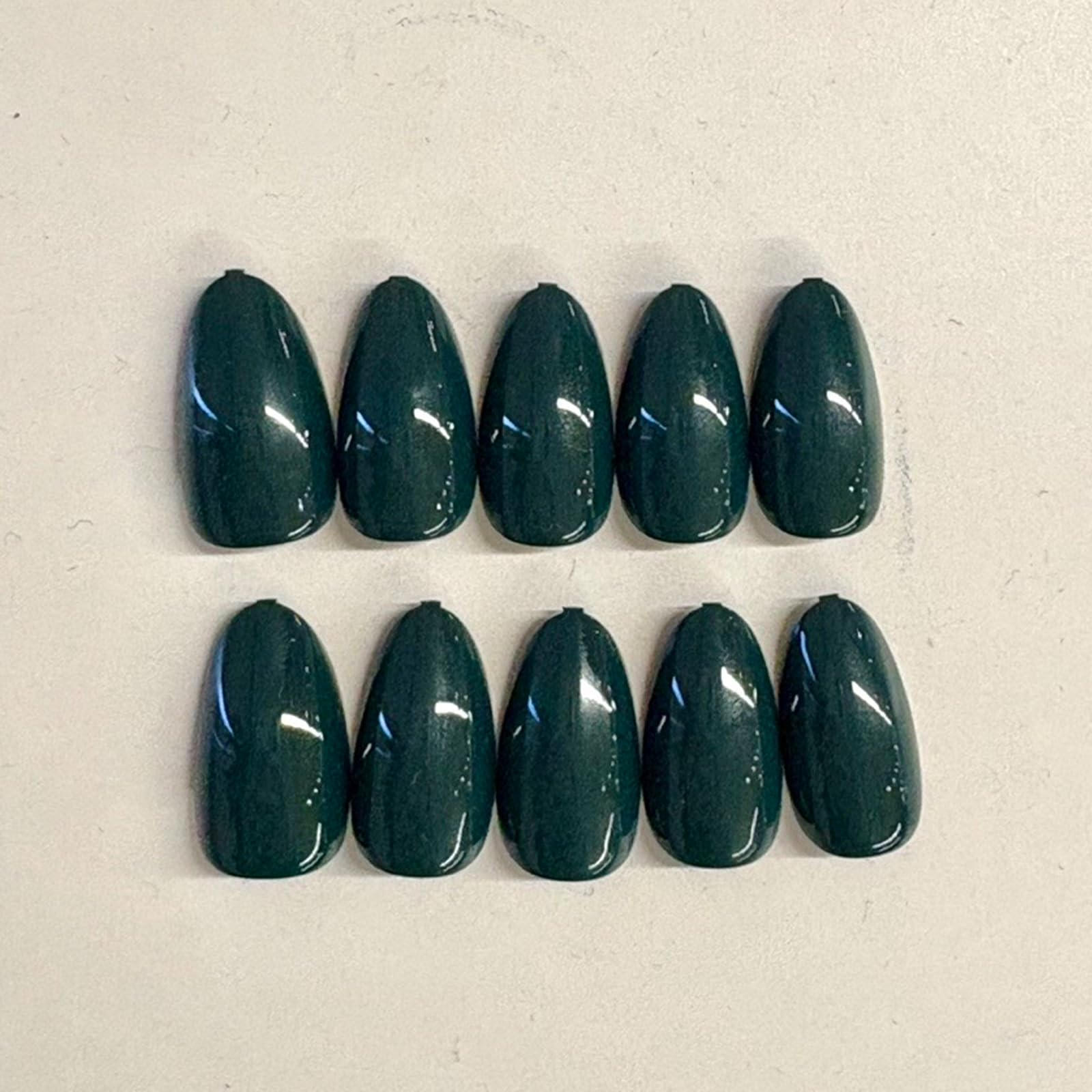 Modelones almond green nails highlight shape and versatile styling.