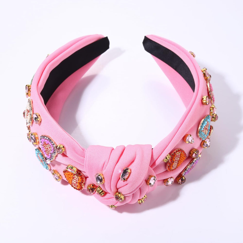 MOLOCH pink heart headband with conversation-heart charms enhances romantic outfits.