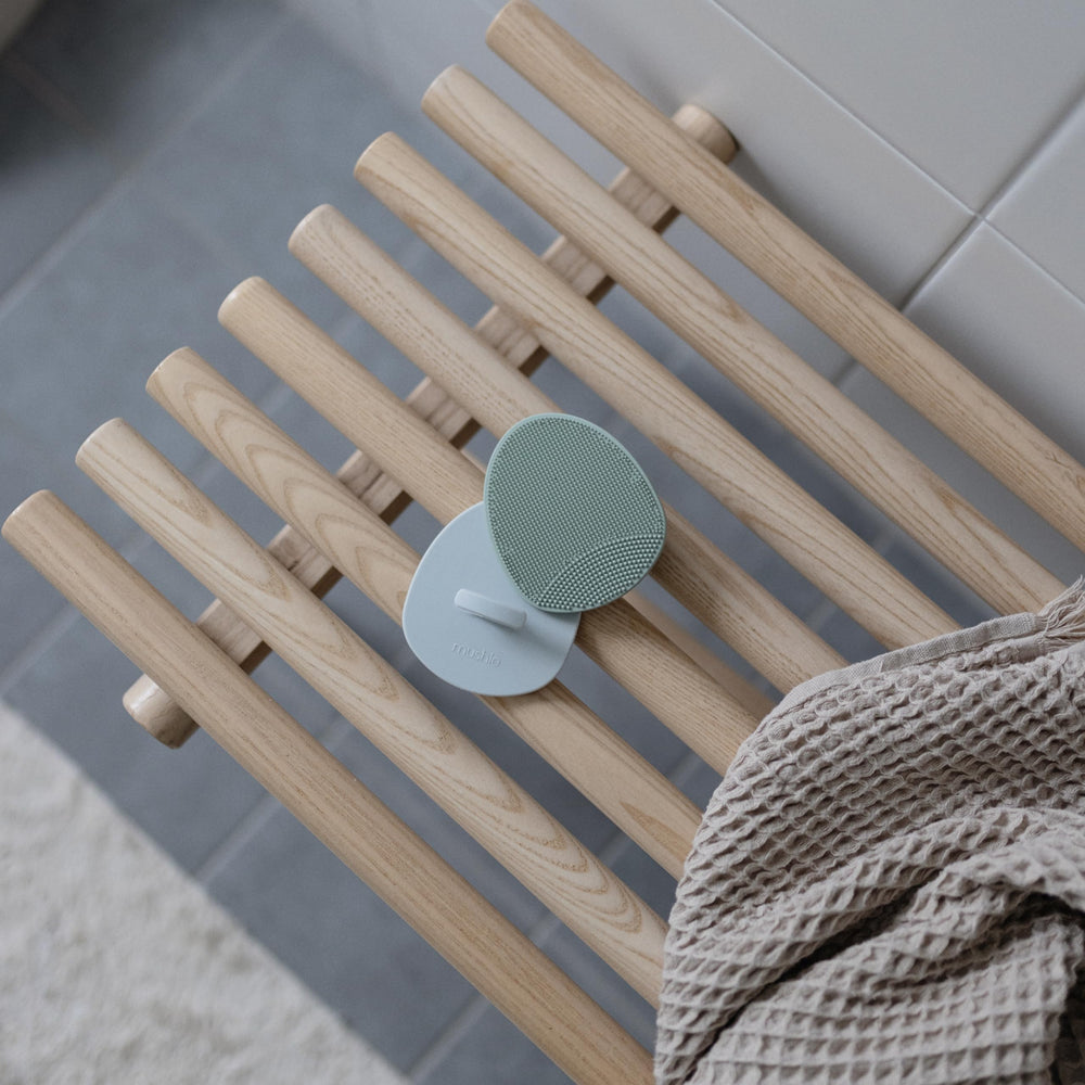 Frotar en círculos con limpiador usando Mushie para baño