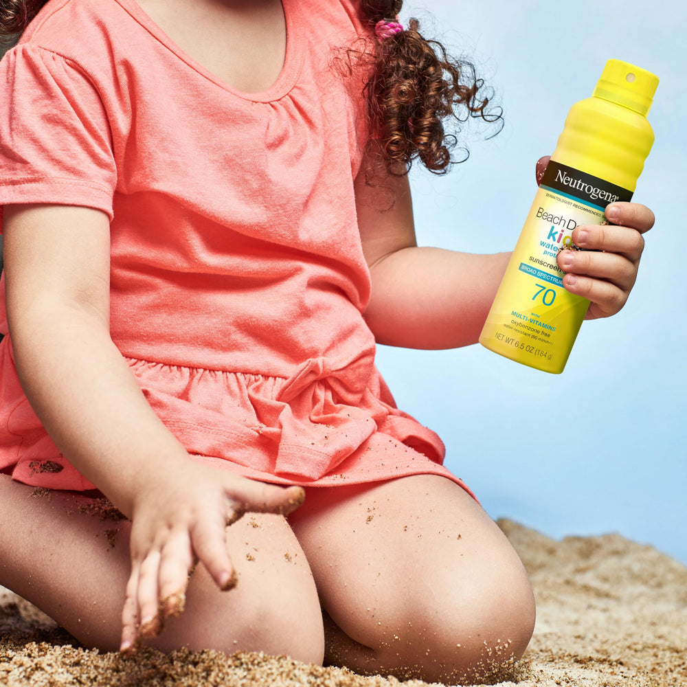 Kids playing at the beach with Neutrogena sunscreen in use.