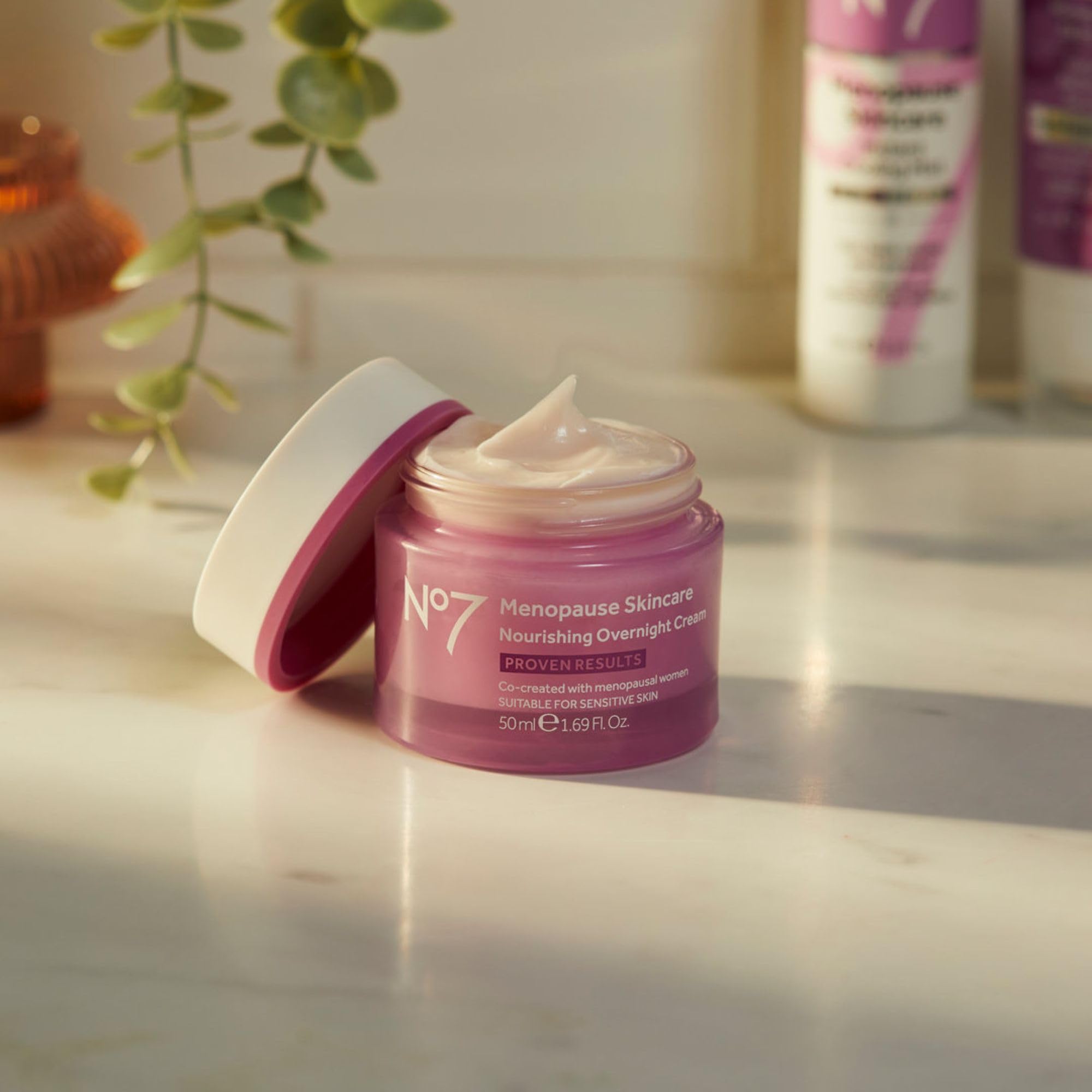 Hand applying No7 night cream to the face for overnight moisturization.