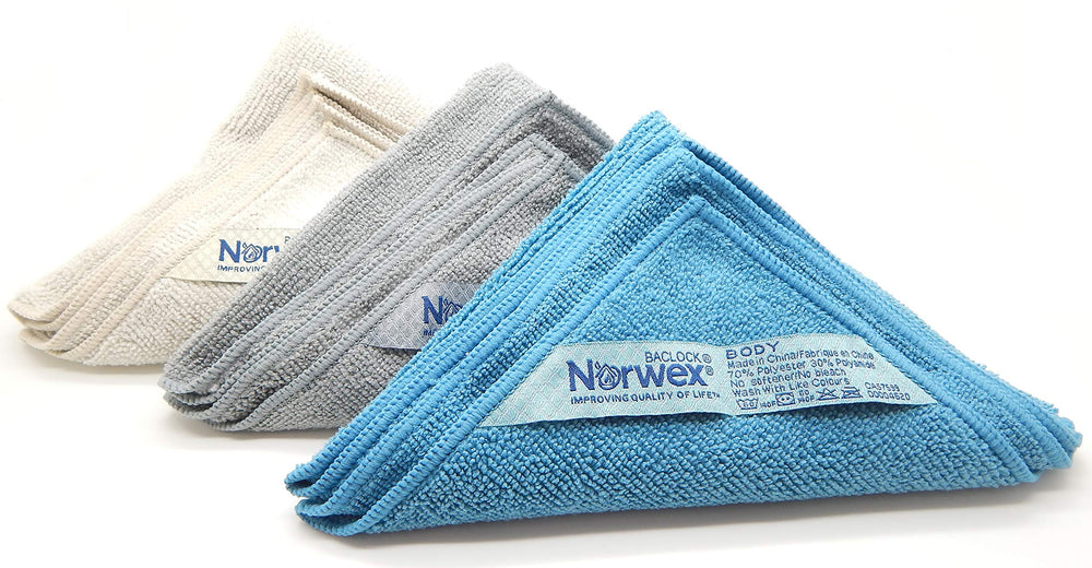 Norwex Paño corporal costero, en mano, listo para uso rápido y reutilizable.