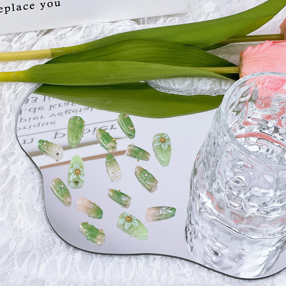 NZRAESTRS almond-shaped nails in green with delicate accents