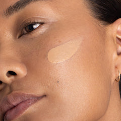 Applying OneSkin OS-01 Shield tinted sunscreen to the face with gentle massage.