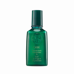 Oribe Eternal Curls Polish & Protect Oil bottle on vanity highlights frizz control and shine.