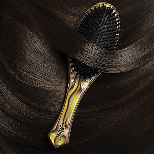 Oribe Flat Brush demonstrates ergonomic grip in use for precise styling.