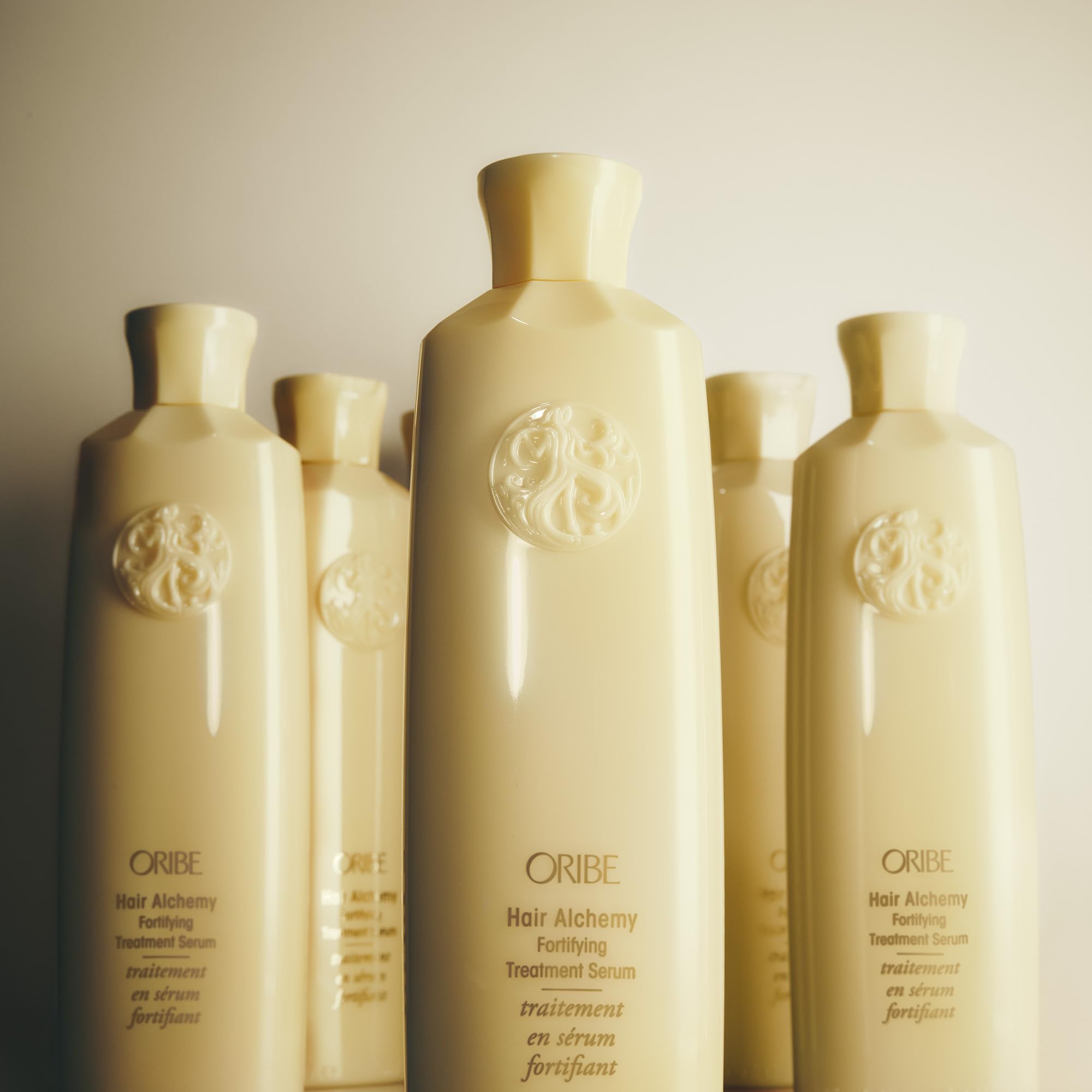 Oribe Hair Alchemy Fortifying Treatment serum visible on strands hints at silky strengthened results