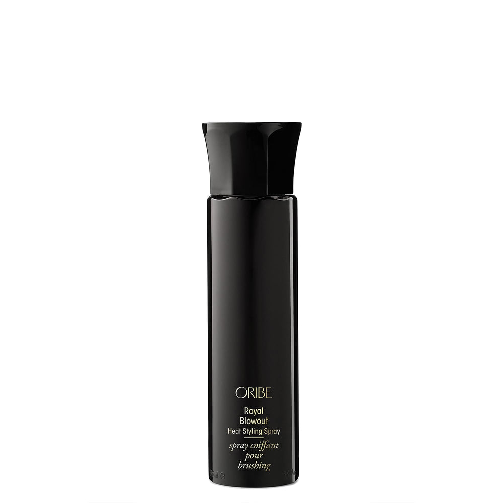 Oribe Royal Blowout spray bottle releasing a light mist for smooth, protected hair.